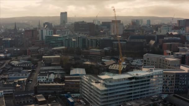 Sheffield, UK - 1st December 2019: Aerial view of a crane and construction sites around Sheffield City, South Yorkshire, during a beautiful cold sunrise — Stock Video