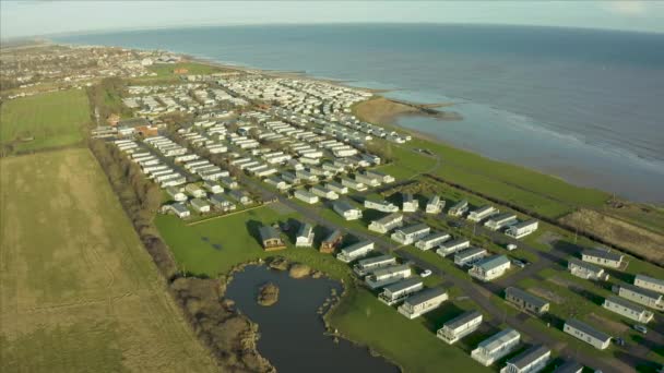 Aerial footage of stationary caravan holiday homes in a trailer park sat on a cliff along the east coast next to the sea in Hornsea, East Yorkshire, UK — 비디오