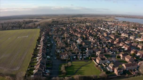 Imágenes aéreas de una urbanización junto a un gran campo durante un sol bajo y un amanecer dorado en Hornsea, East Yorkshire, Reino Unido — Vídeos de Stock