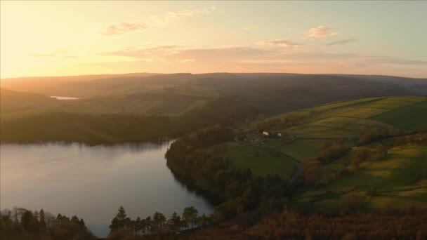 Flygbilder flyger över lugna stilla sjön Agden Reservoir vid solnedgången över Bradfield byn i Sheffield, Peak District National Park, Yorkshire och Derbyshire, Storbritannien. december 2019. — Stockvideo