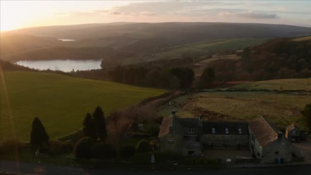 Riprese aeree di una vecchia casa colonica nel verde lussureggiante campagna inglese e cieli limpidi al tramonto a Sheffield, Peak District National Park, Yorkshire e Derbyshire, Regno Unito. dicembre 2019 . — Video Stock