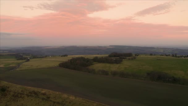Aerial footage flying over fields and meadows at sunset in Sheffield, Peak District National Park, Yorkshire and Derbyshire, UK. December 2019. — 비디오