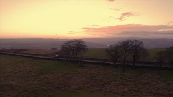 Flygfoto av vacker sluttning under solnedgången över en liten smal väg på landsbygden på vintern — Stockvideo