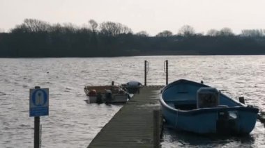 Rowing boats tied up to a dock during the cold winter months in Hornsea, East Yorkshire, UK