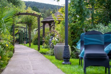 Weddding chairs next to pathed path at outdoor wedding in the summer months with bright lush green grass