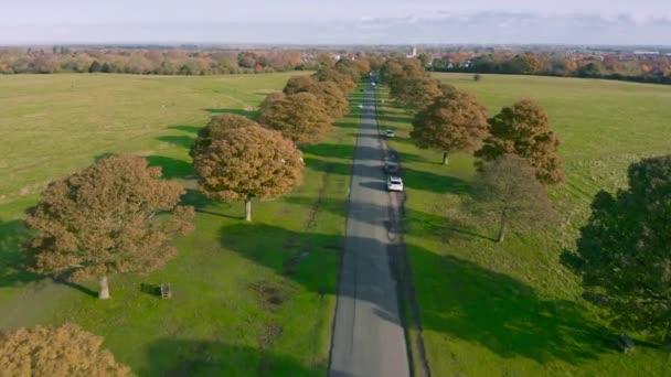 Aerial footage along road of parked cars in English Rural Countryside in autumn — Stock Video