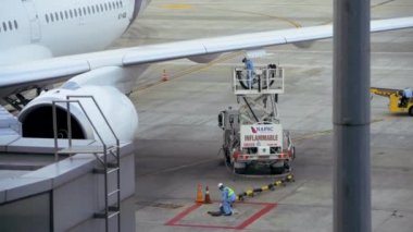 Hanoi, Vietnam - 24 Ekim 2019: Havayolu mürettebatı, Hanoi Uluslararası Havaalanı 'ndan kalkışa hazırlanan yolcu uçağına yakıt ikmali yapıyor.