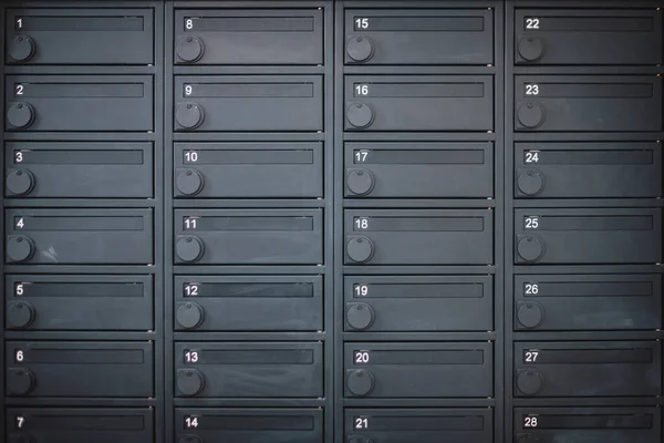 A row of metal deposit boxes or mail boxes in a dark grey colour in an apartment — Stock Photo, Image