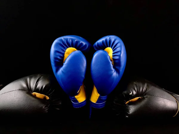 Boxing gloves on a black background. Sports accessories for boxing. Leather gloves for martial arts. The will to win, fortitude