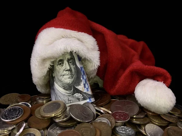 Noel şapkasına 100 dolar. Dolar, yabancı metal paraların üstünde. Banknotta kırmızı başlıklı Benjamin Franklin vardı. Yeni yıl dolarları, siyah bir arkaplanda..