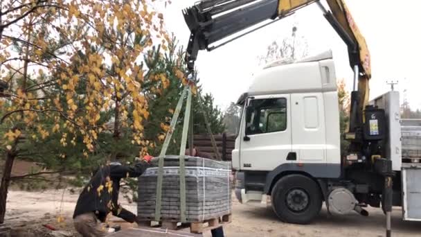 从卡车上卸下铺装板 人们用机械手卸下铺路板 工人们从一台大机器上卸下建筑材料 2019年11月8日 基辅地区 Dmitrovka — 图库视频影像