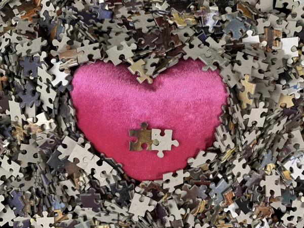 Struttura dello sfondo: forma del cuore su sfondo di carta puzzle. Puzzle nei dettagli sotto forma di mosaico. Concetto: amore, relazioni, unità, cordialità . — Foto Stock