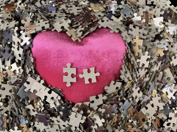 Struttura dello sfondo: forma del cuore su sfondo di carta puzzle. Puzzle nei dettagli sotto forma di mosaico. Concetto: amore, relazioni, unità, cordialità . — Foto Stock