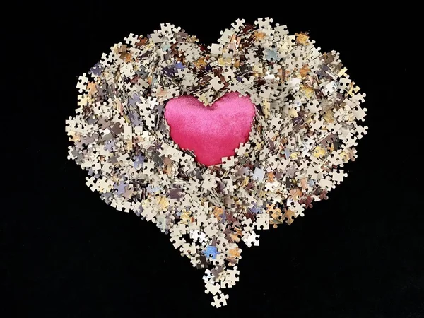 Struttura dello sfondo: forma del cuore su sfondo di carta puzzle. Puzzle nei dettagli sotto forma di mosaico. Concetto: amore, relazioni, unità, cordialità . — Foto Stock