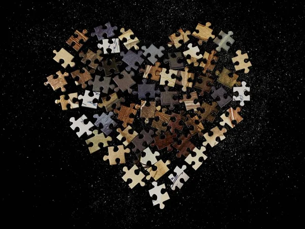 Struttura dello sfondo: forma del cuore su sfondo di carta puzzle. Puzzle nei dettagli sotto forma di mosaico. Concetto: amore, relazioni, unità, cordialità . — Foto Stock