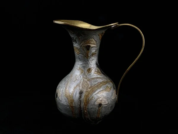 Koper antieke vaas op een zwarte achtergrond. Koperen schotels met patronen en ornamenten. Metalen kruik voor huisdecoratie. — Stockfoto
