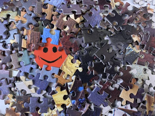 Image of a happy face on cardboard. Puzzle in the details in the form of a mosaic. Concept: joy, happiness, positive, kindness.