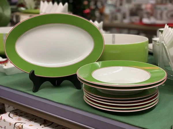A set of bright plates on a set of kitchen plates on a store shelf. Stack of ceramic dishes in a supermarket.