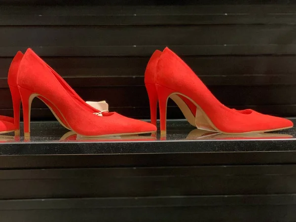 Klasické, půvabné dámské boty na vysokých podpatcích. Jasné dámské boty na tmavém pozadí v obchodě s obuví. Pár bot pro ženy. — Stock fotografie