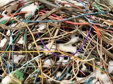 Bir sürü kullanılmış elektrik kablosu. Garajda bir elektrikçinin kabloları var. Bir araba servisinde çok renkli kablolar