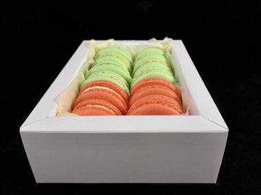 Siyah arka planda çok renkli, lezzetli badem kurabiyeleri. Değişik zevkleri olan renkli Fransız badem kurabiyeleri. Orijinal tatlı, ev yapımı kekler..