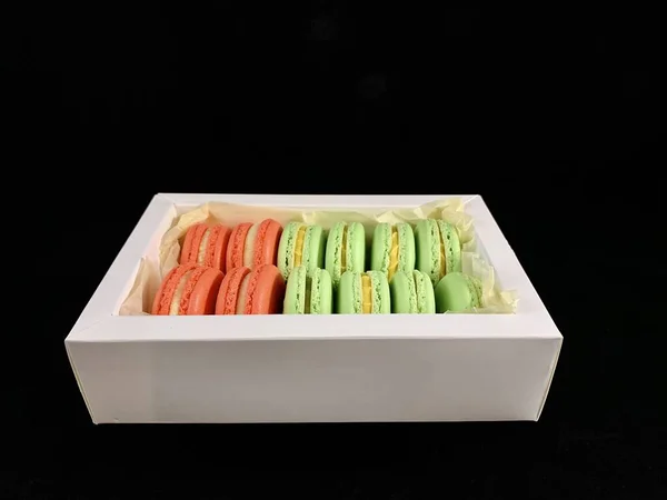 Macarons savoureux multicolores sur fond noir. Macarons français colorés de différents goûts, vue de dessus. Dessert original, gâteaux faits maison . — Photo