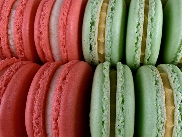 Multicolored tasty macarons on a black background. Colorful french macarons of various tastes, top view. Original dessert, homemade cakes. — 스톡 사진