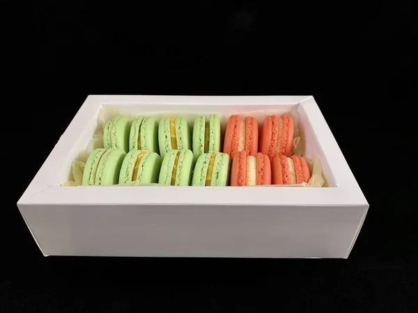 Multicolored tasty macarons on a black background. Colorful french macarons of various tastes, top view. Original dessert, homemade cakes. — 스톡 사진