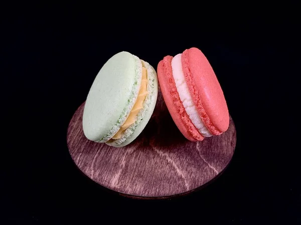 Mehrfarbige leckere Macarons auf schwarzem Hintergrund. farbenfrohe französische Macarons in verschiedenen Geschmacksrichtungen, Draufsicht. original Dessert, hausgemachte Kuchen. — Stockfoto