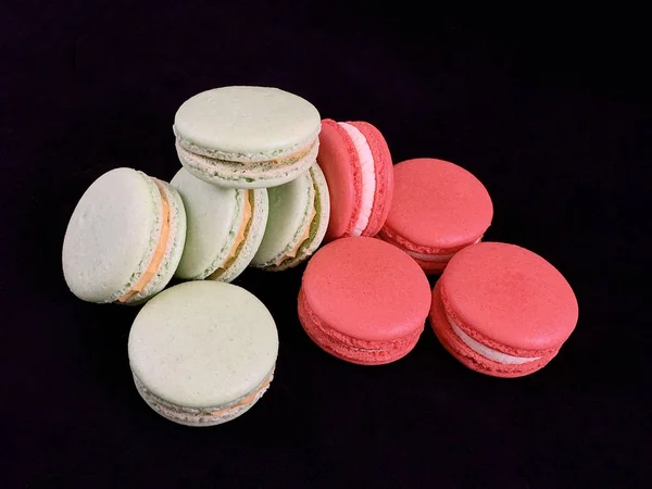 Mehrfarbige leckere Macarons auf schwarzem Hintergrund. farbenfrohe französische Macarons in verschiedenen Geschmacksrichtungen, Draufsicht. original Dessert, hausgemachte Kuchen. — Stockfoto