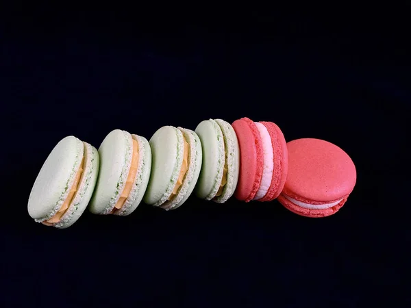 Mehrfarbige leckere Macarons auf schwarzem Hintergrund. farbenfrohe französische Macarons in verschiedenen Geschmacksrichtungen, Draufsicht. original Dessert, hausgemachte Kuchen. — Stockfoto