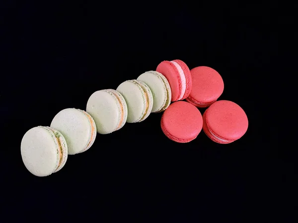 Multicolored tasty macarons on a black background. Colorful french macarons of various tastes, top view. Original dessert, homemade cakes. — 스톡 사진