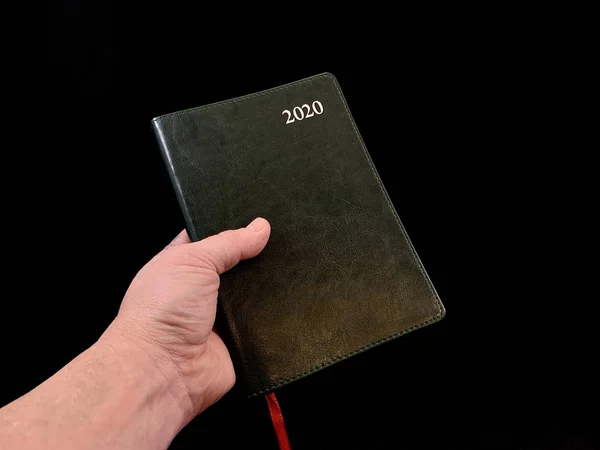 Caderno - um diário encadernado em couro, em um contexto preto. Caderno para planejamento de tempo . — Fotografia de Stock