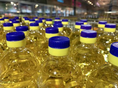 Plastik şişelerde parlak kapaklı ayçiçeği yağı. Temiz sebze yağıyla dolu bir sürü şişe. Ayçiçeği yağı ticareti, satış.