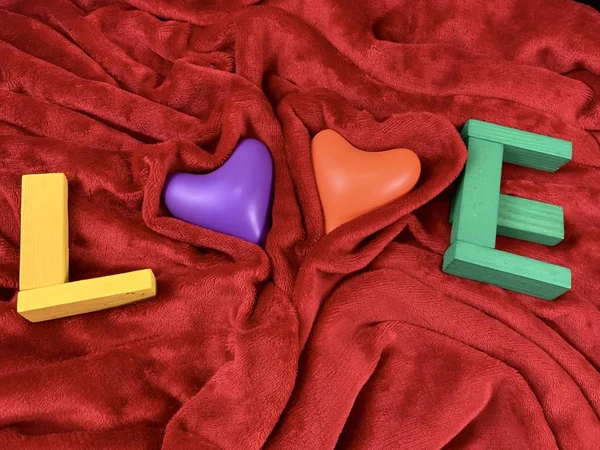 Multi-gekleurde harten op zachte stof. Twee harten op een rode deken. Concept: Valentijnsdag, liefde — Stockfoto