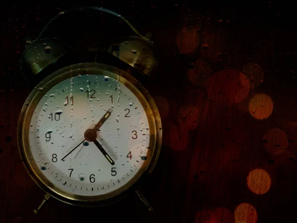 黑色背景上的老式闹钟。 全天候多彩的灯。 台面机械钟上有数字。 概念：时间之谜 — 图库照片