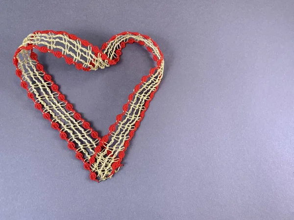 Cuore realizzato in nastro con pizzo, sfondo isolato. Forma del cuore fatta di nastro decorativo con motivi. Elemento per biglietto da visita, San Valentino, invito di nozze . — Foto Stock