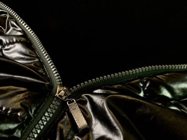 Background texture: zipper in a jacket on a black background. Opened lock on knit fabric.
