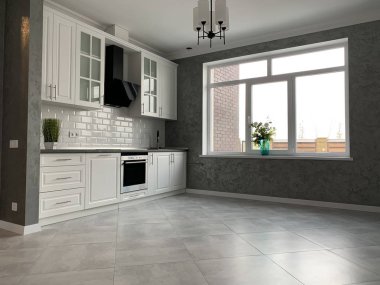 White kitchen furniture with black countertops. New modern kitchen with hood and sink.
