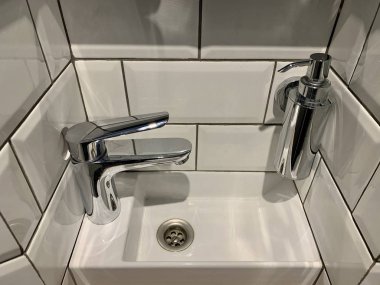 Musluğu olan küçük bir lavabo. Yeni bir evde modern tasarımcı tesisatı..