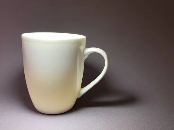 Porcelain or ceramic cup on a gray background. A large mug with a handle for tea or coffee. — ストック写真