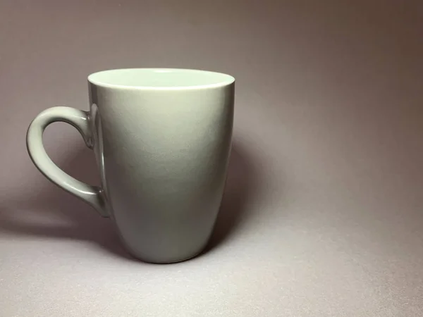 Porcelain or ceramic cup on a gray background. A large mug with a handle for tea or coffee. — ストック写真