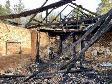 Gökyüzüne karşı çıkan yangından sonra yıkılmış eski bir ev. Kapısı ve penceresi olmayan, çatısı kırık terk edilmiş bir ev. Kavram: Yıkım, yalnızlık