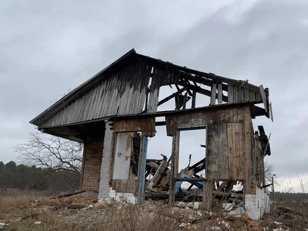 Old destroyed house after a fire against the sky. Abandoned house with no doors and windows with a broken roof. Concept: devastation, desolation — Stock Photo, Image