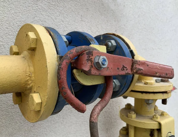Железный рычаг на газопроводе. Клапан разделения трубопроводного газа. Желто-голубая газовая труба с демпфером . — стоковое фото