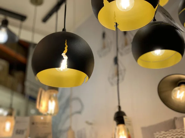 Originali plafoniere giallo-nere. Lampadari moderni nel negozio di elettrodomestici. Lampade da terra a sospensione per la decorazione d'interni . — Foto Stock