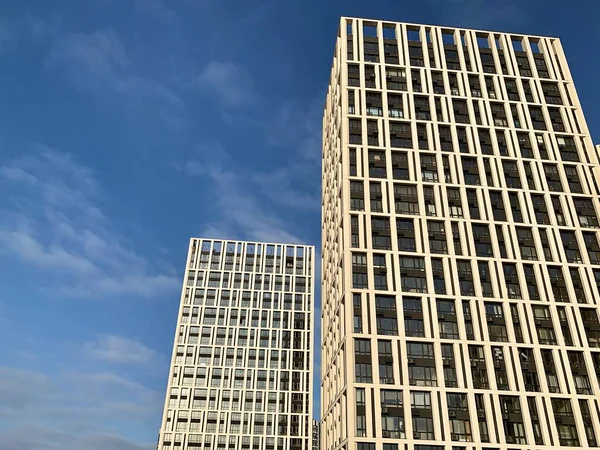 Висотна будівля на тлі блакитного неба. Висока нова будівля з дзеркальними вікнами, вид знизу. Текстура тла: офісна будівля . — стокове фото