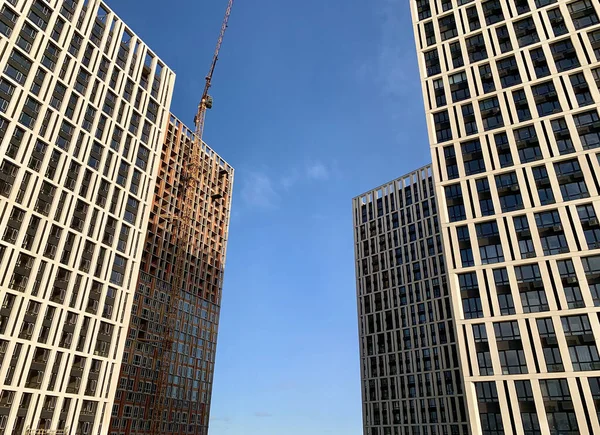 Edifício alto em um fundo de céu azul. Novo edifício alto com janelas espelhadas, vista de baixo. Textura de fundo: edifício de escritórios . — Fotografia de Stock