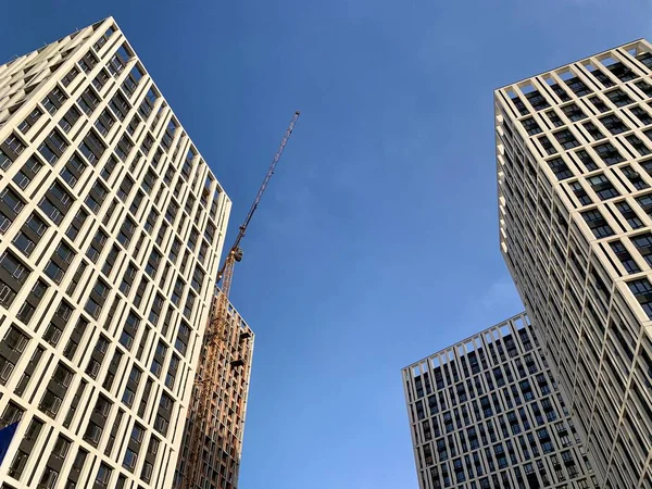 Edifício alto em um fundo de céu azul. Novo edifício alto com janelas espelhadas, vista de baixo. Textura de fundo: edifício de escritórios . — Fotografia de Stock