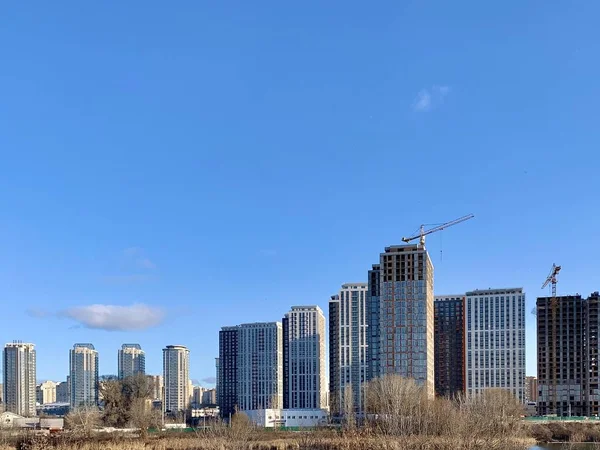 Microdistrito com edifícios altos, contra o céu azul. A construção de novas casas de arranha-céus, o plano geral. O novo distrito de Kiev, 7 de fevereiro de 2020 . — Fotografia de Stock